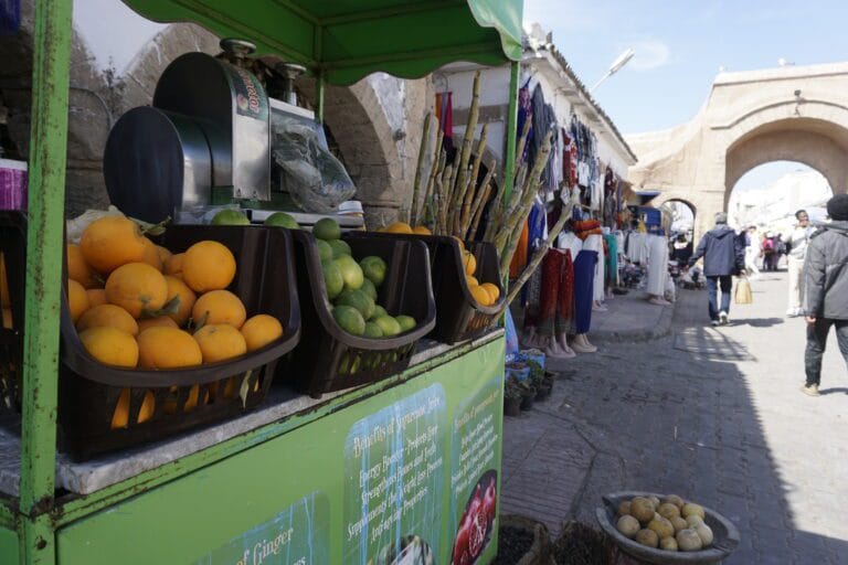 A green cart filled with vibrant fruits, including oranges and other citrus, representing Moroccan juice culture