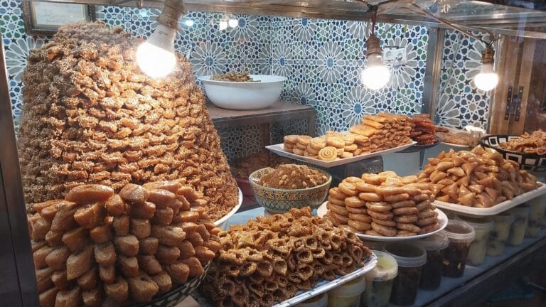 A display case showcasing an assortment of Moroccan sweets and pastries, highlighting their vibrant colors and intricate designs.
