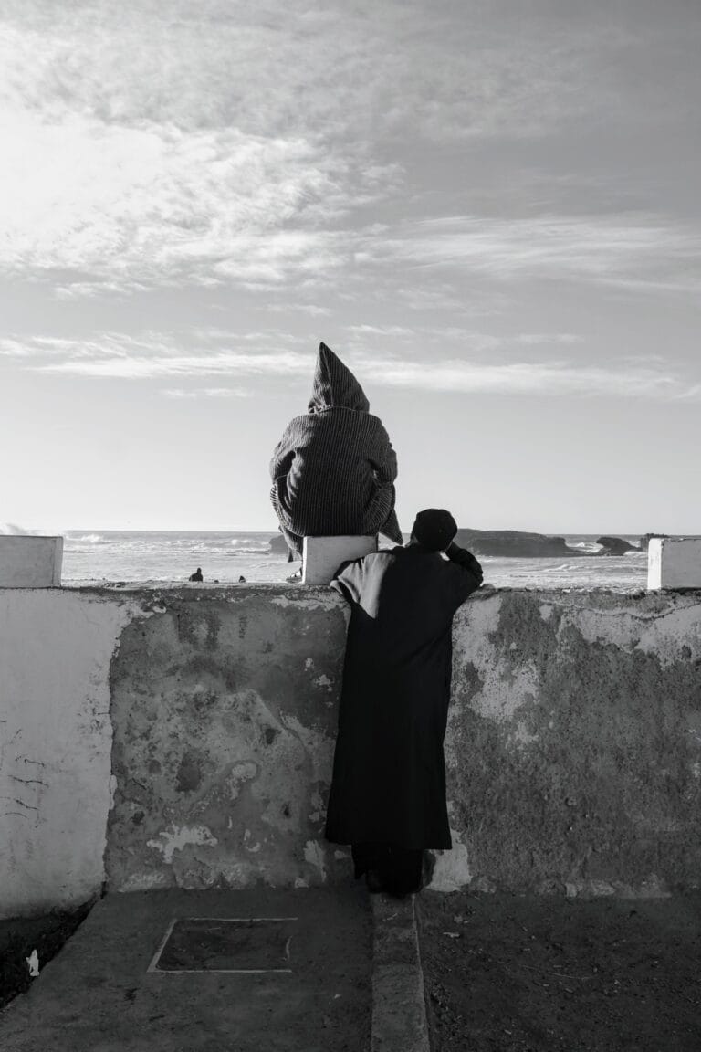 Two men looking at the ocean and the beach in Essaouira