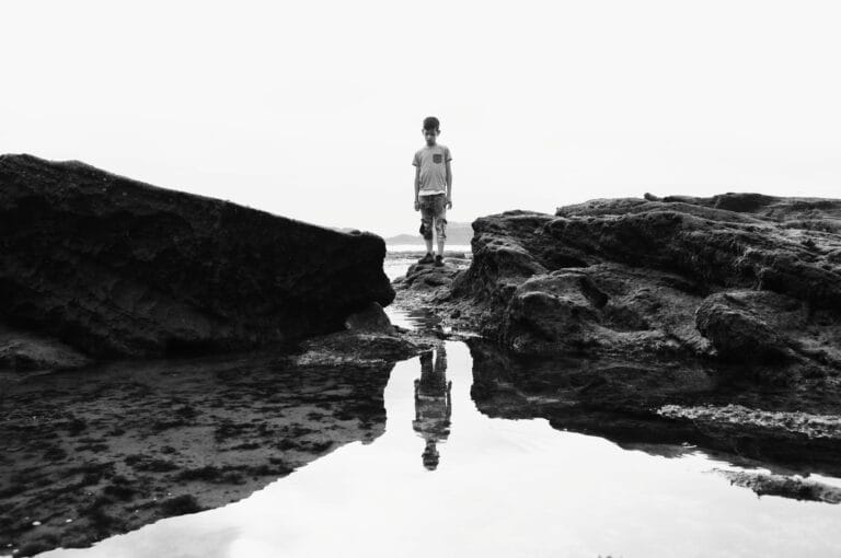 A child standing on the beach of Essaouira and looking at the water