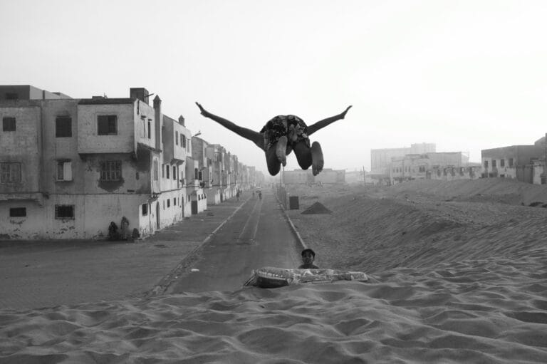 Moroccan children jumping and playing on the beach of a local neighborhood of Essaouira