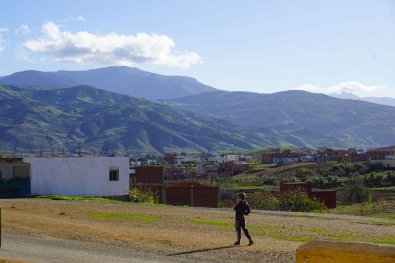 Panoramic view of the Oued Laou countryside with a child walking on a road towards the village.