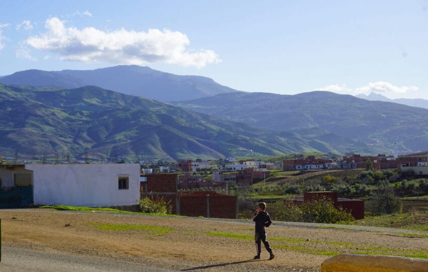 Panoramic view of the Oued Laou countryside with a child walking on a road towards the village.