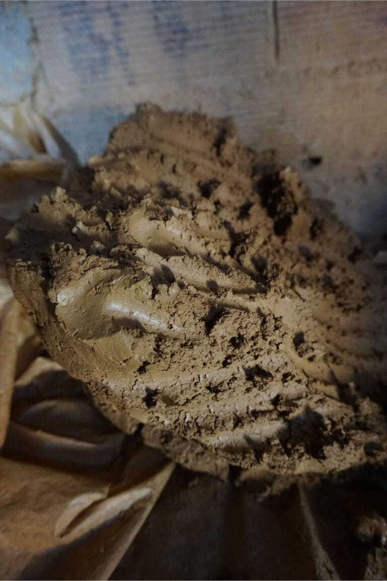 A prepared block of wet, natural red clay ready for a pottery workshop.