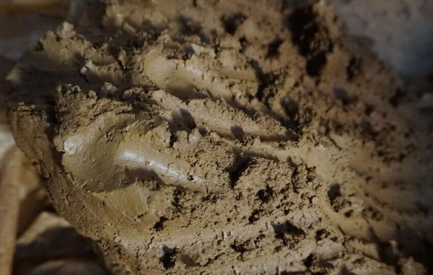 A prepared block of wet, natural red clay ready for a pottery workshop.